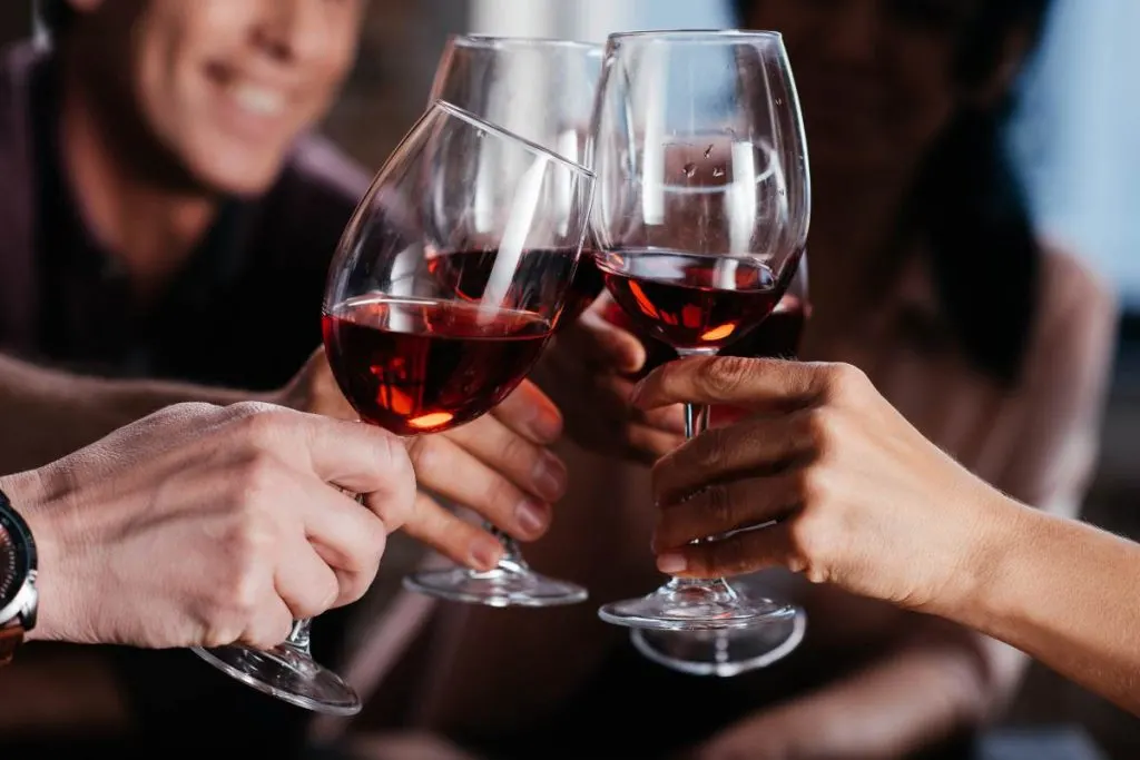 Un gruppo di persone che brinda con bicchieri di vino rosso spagnolo.